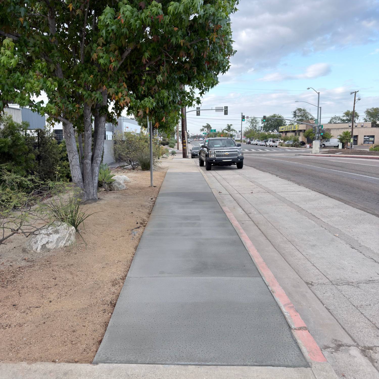 Finished replacement sidewalk along a San Diego street — new concrete to City spec