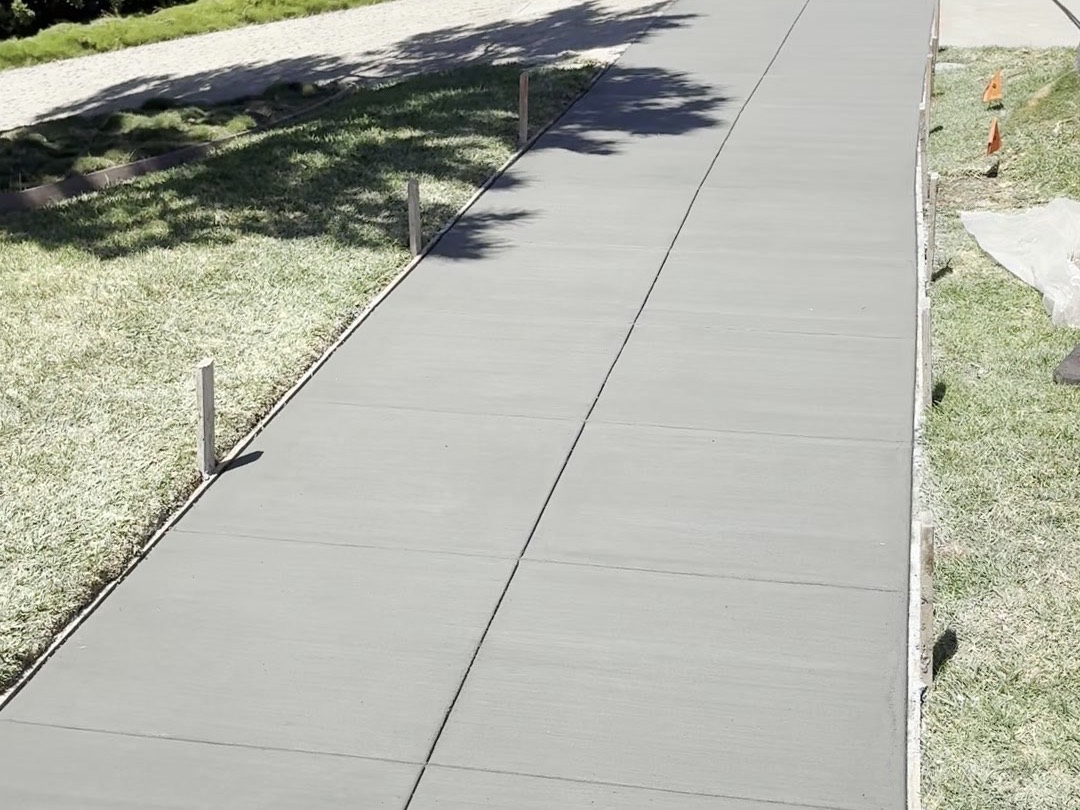 Freshly poured replacement sidewalk in San Diego by SD Sidewalks — clean broom finish between green parkway lawns